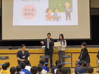スライドを用いて子どもたちに向けて話す様子